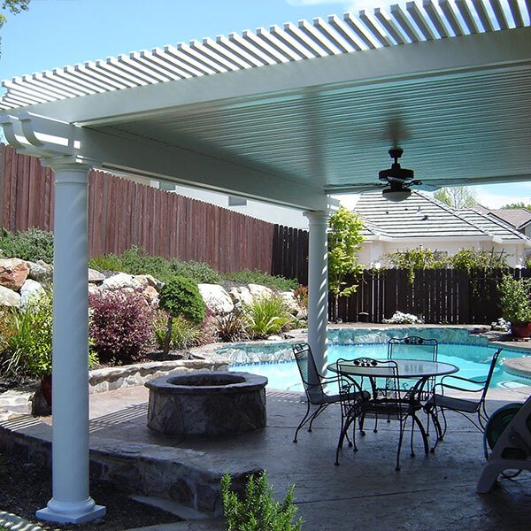 A Louvretec 180 Classic with table and chairs beside a pool.